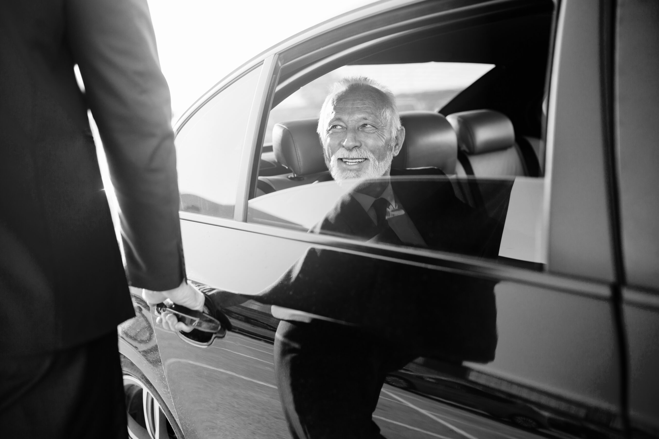Executive passenger receiving professional black car chauffeur service